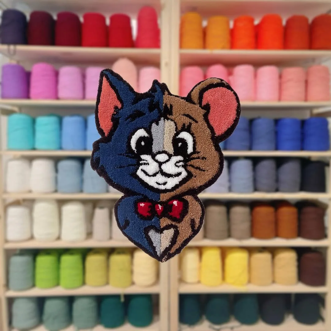 半藍半咖啡的 Tom 貓與 Jerry 鼠合體造型簇絨地毯,背景是整面彩色毛線牆|台北 Tufting 地毯聖誕節約會